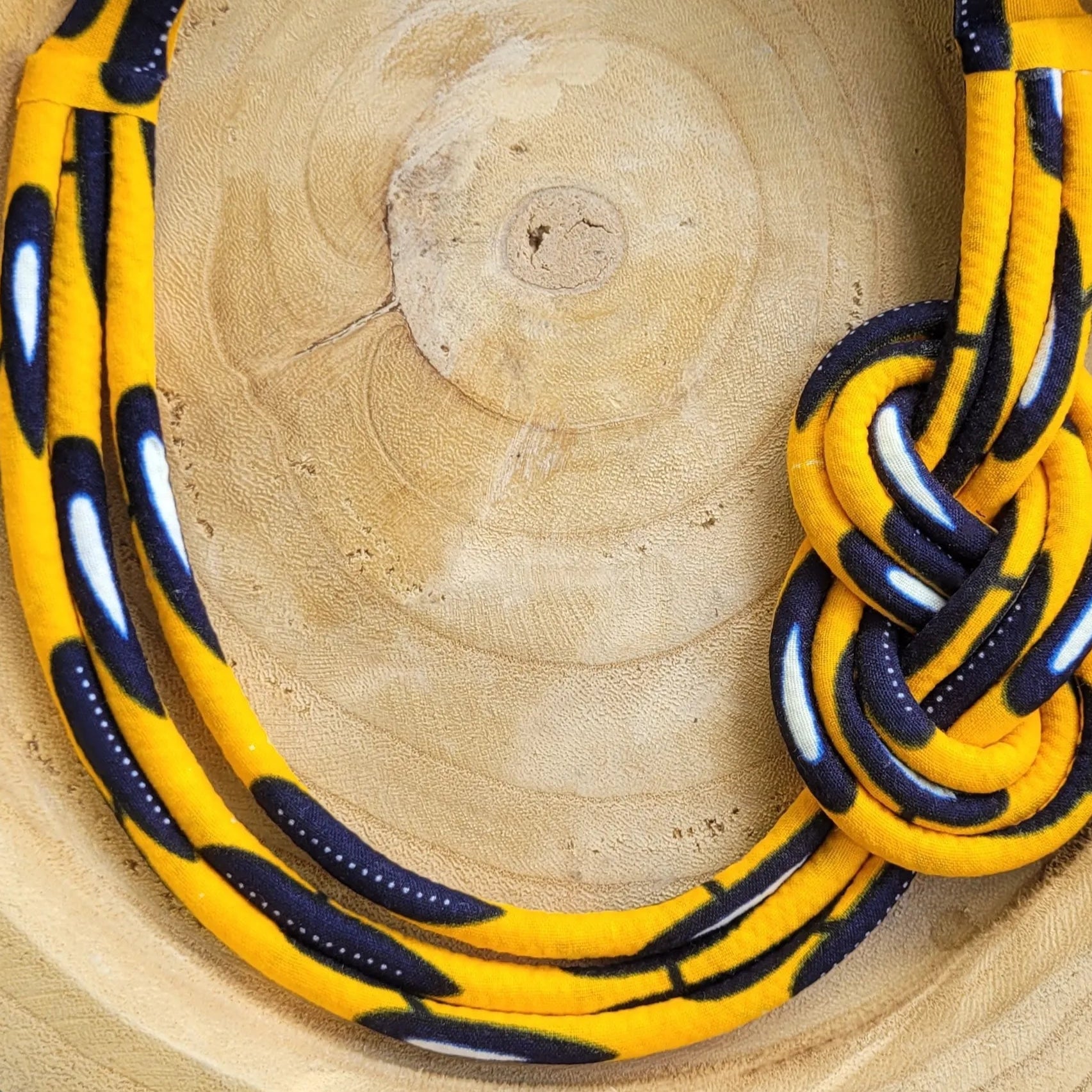 collier en tissu Bineta, un collier coloré composé de trois rangs de cordons recouverts de tissu wax entrelacés