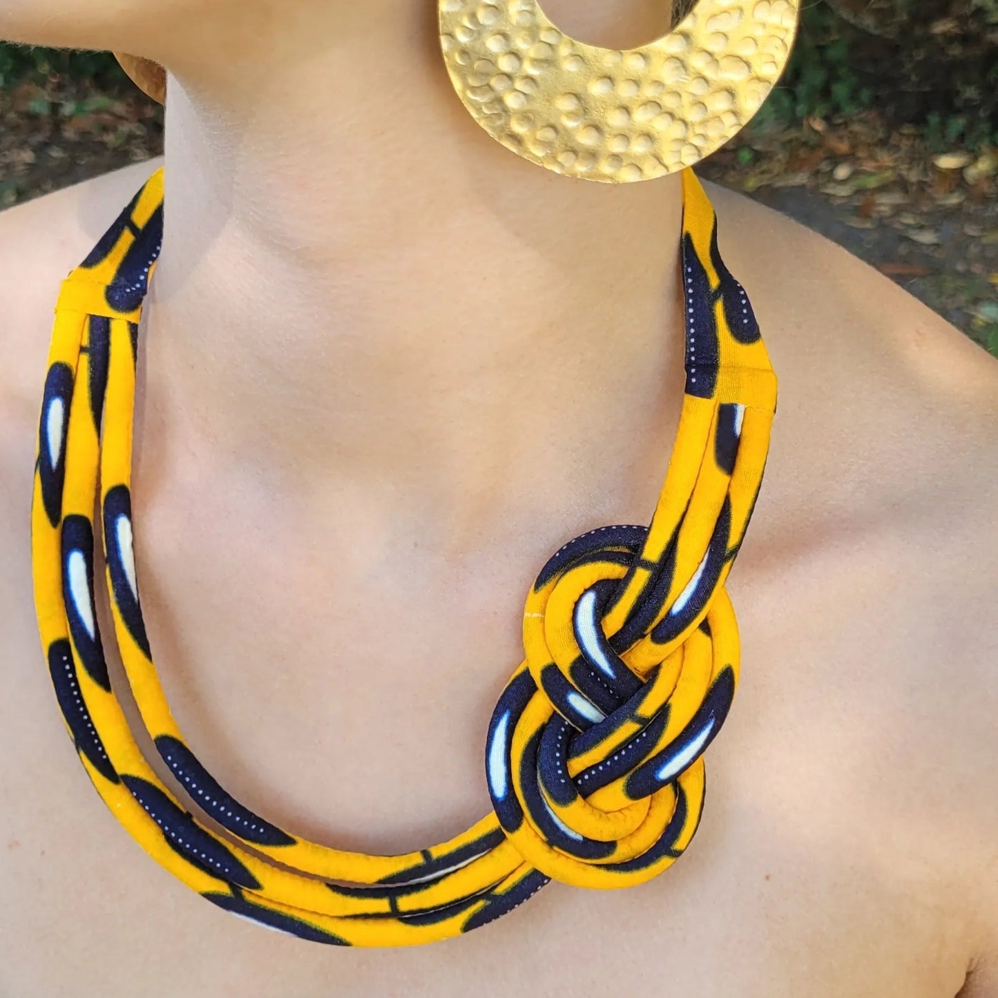 collier en tissu Bineta, un collier ethnique chic composé de trois rangs de cordons recouverts de tissu wax entrelacés