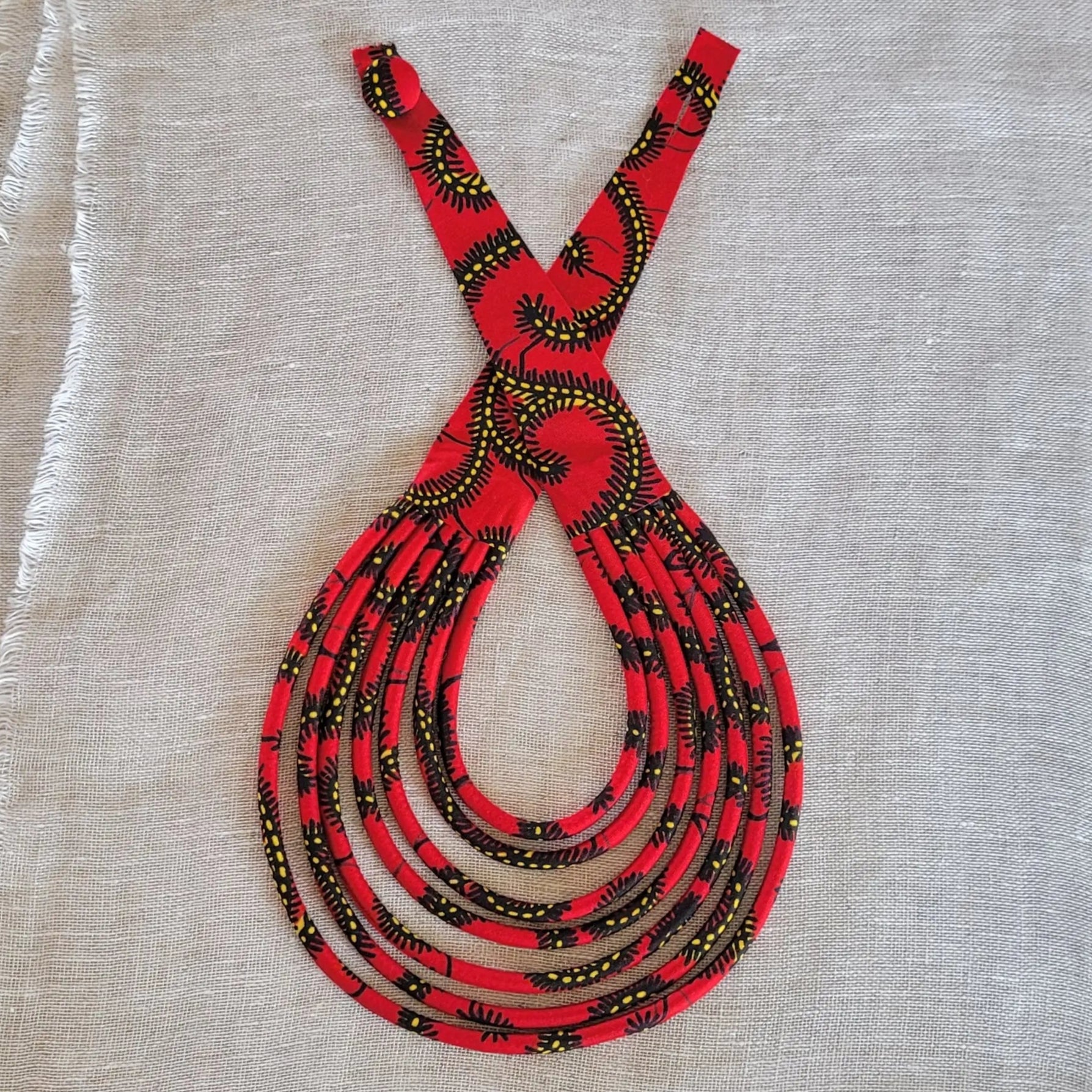 collier en tissu Khadija, un bijou africain traditionnel en pagne noir et rouge 