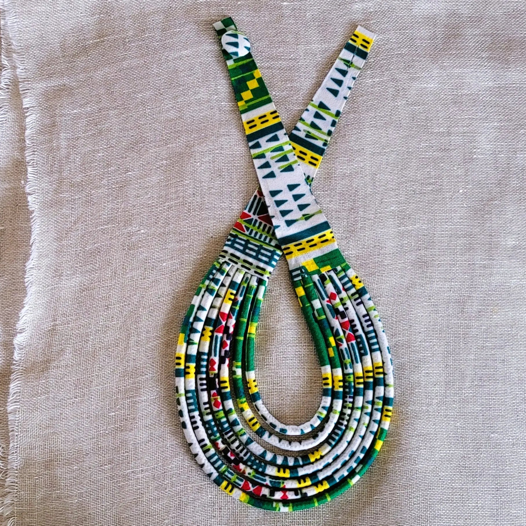 collier en tissu Maguette, un bijou africain traditionnel en pagne vert et blanc 