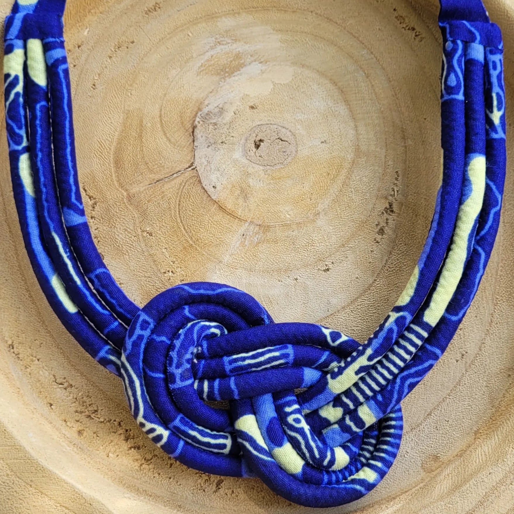 collier en tissu Maïmouna, un collier coloré composé de trois rangs de cordons recouverts de tissu wax entrelacés