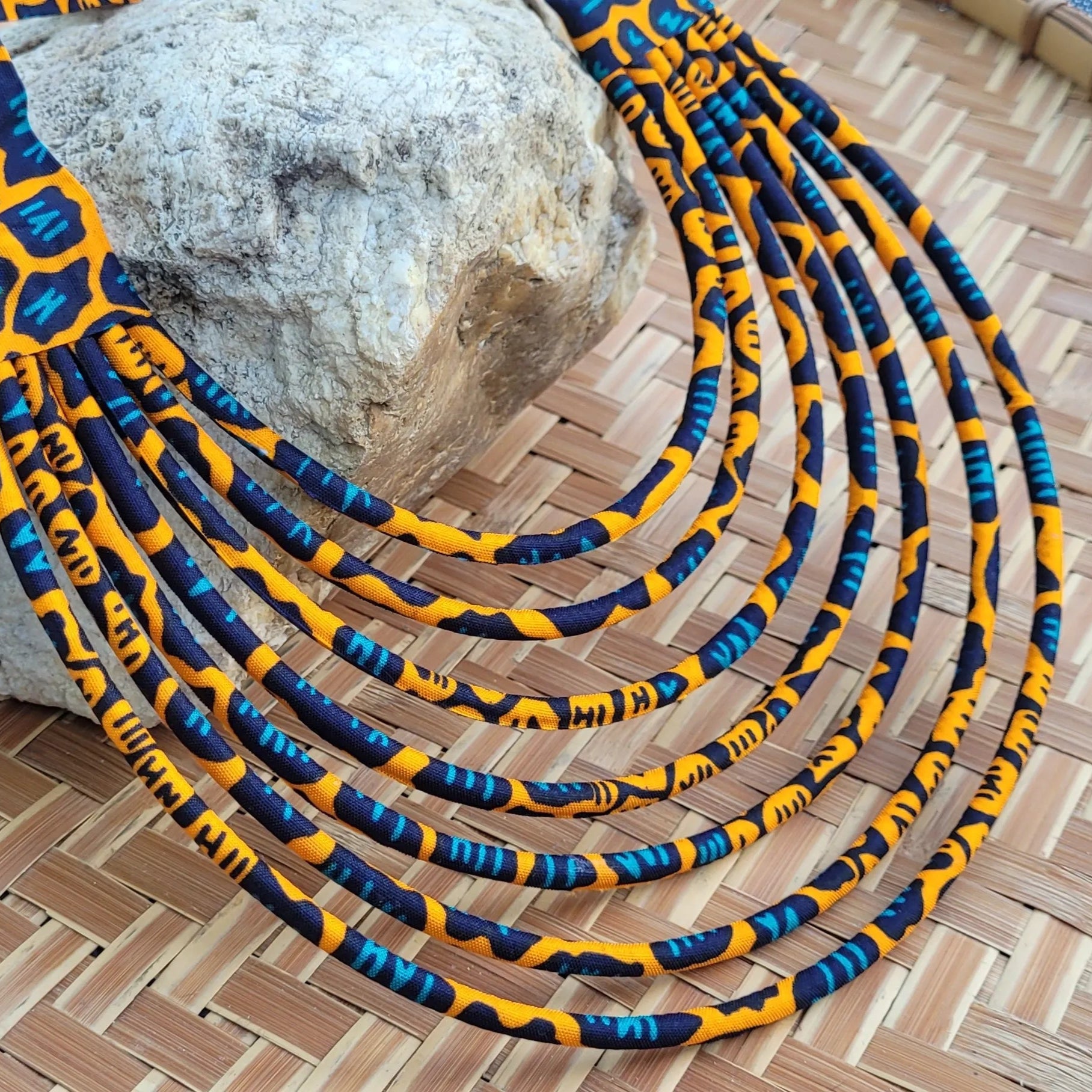 collier en tissu Nabintou, un bijou africain traditionnel en wax orange, noir et bleu canard