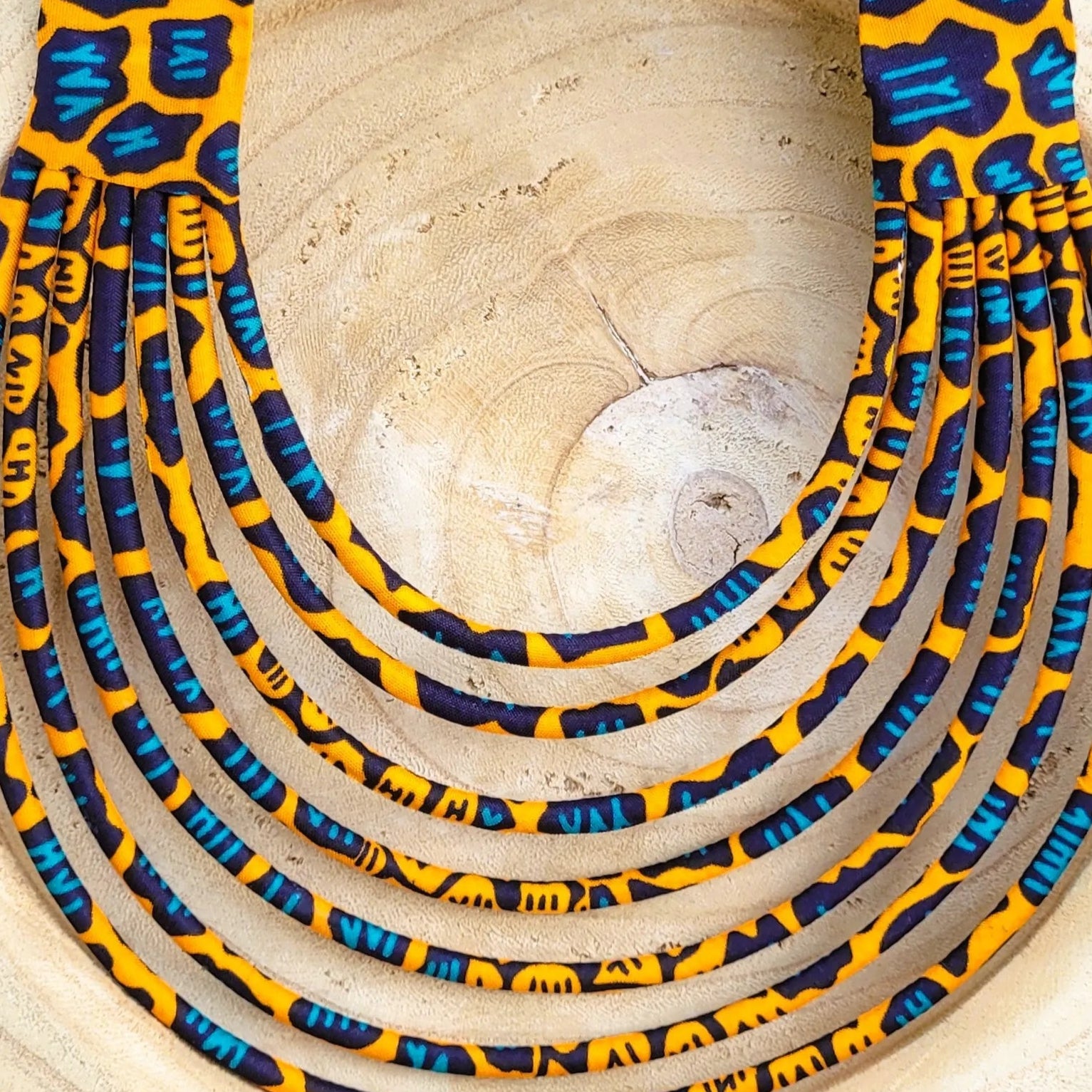 collier en tissu Nabintou, un collier coloré composé de sept rangs de cordons recouverts de tissu wax