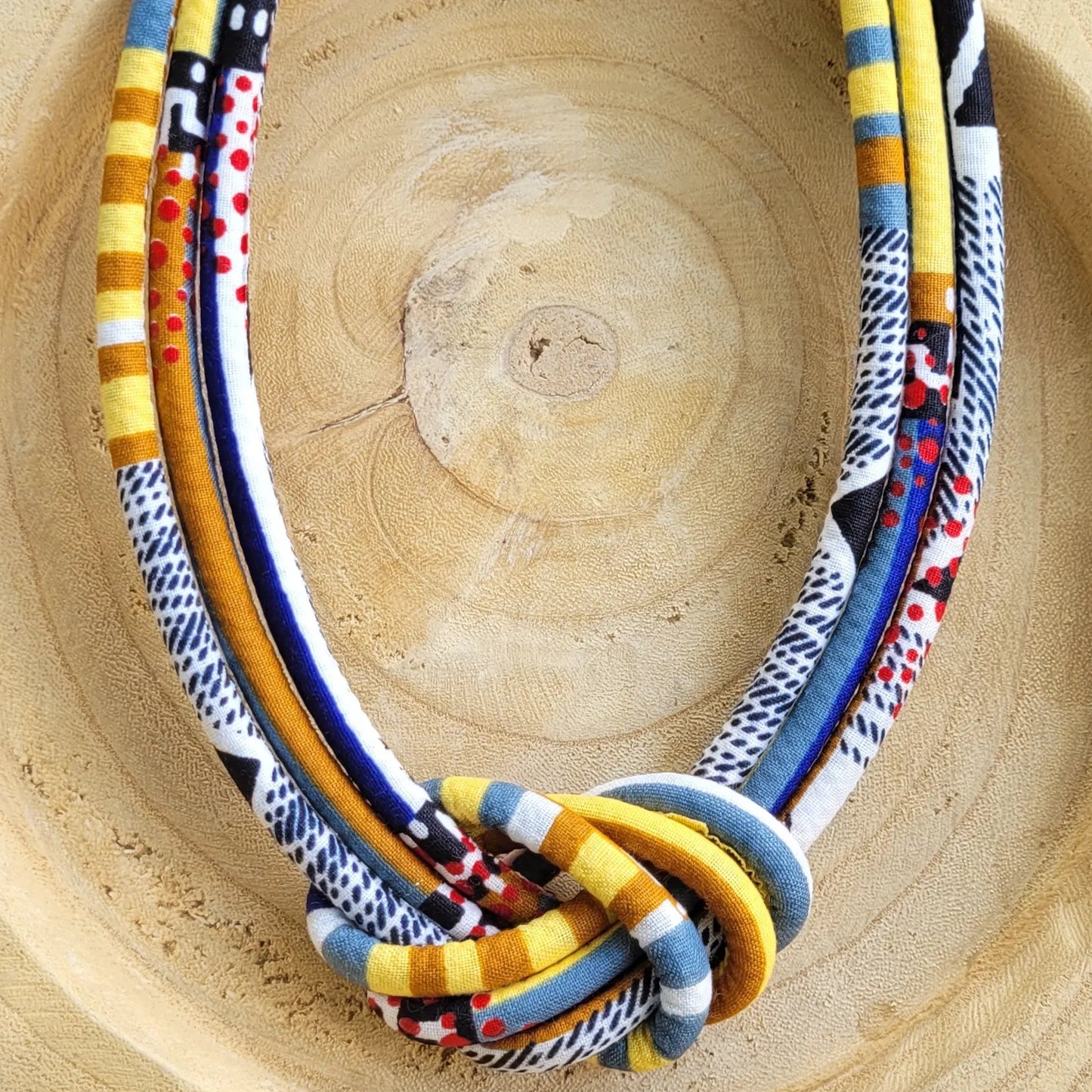collier en tissu Nafissatou, un collier coloré composé de trois rangs de cordons recouverts de tissu wax entrelacés