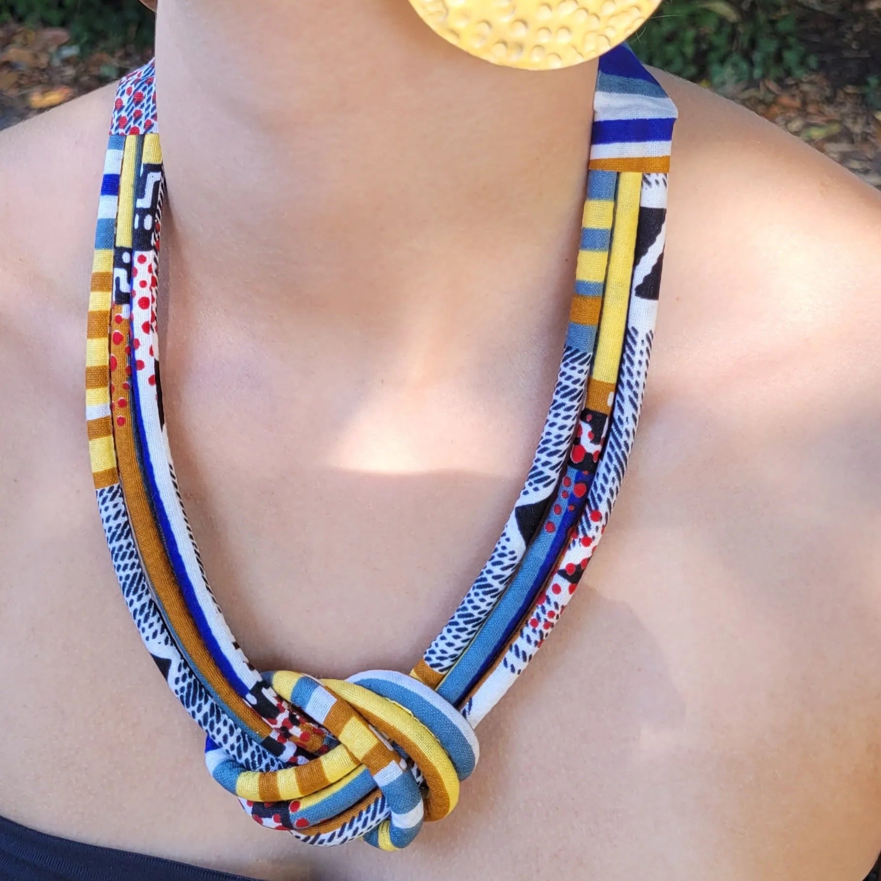 collier en tissu Nafissatou, un collier ethnique chic composé de trois rangs de cordons recouverts de tissu wax entrelacés