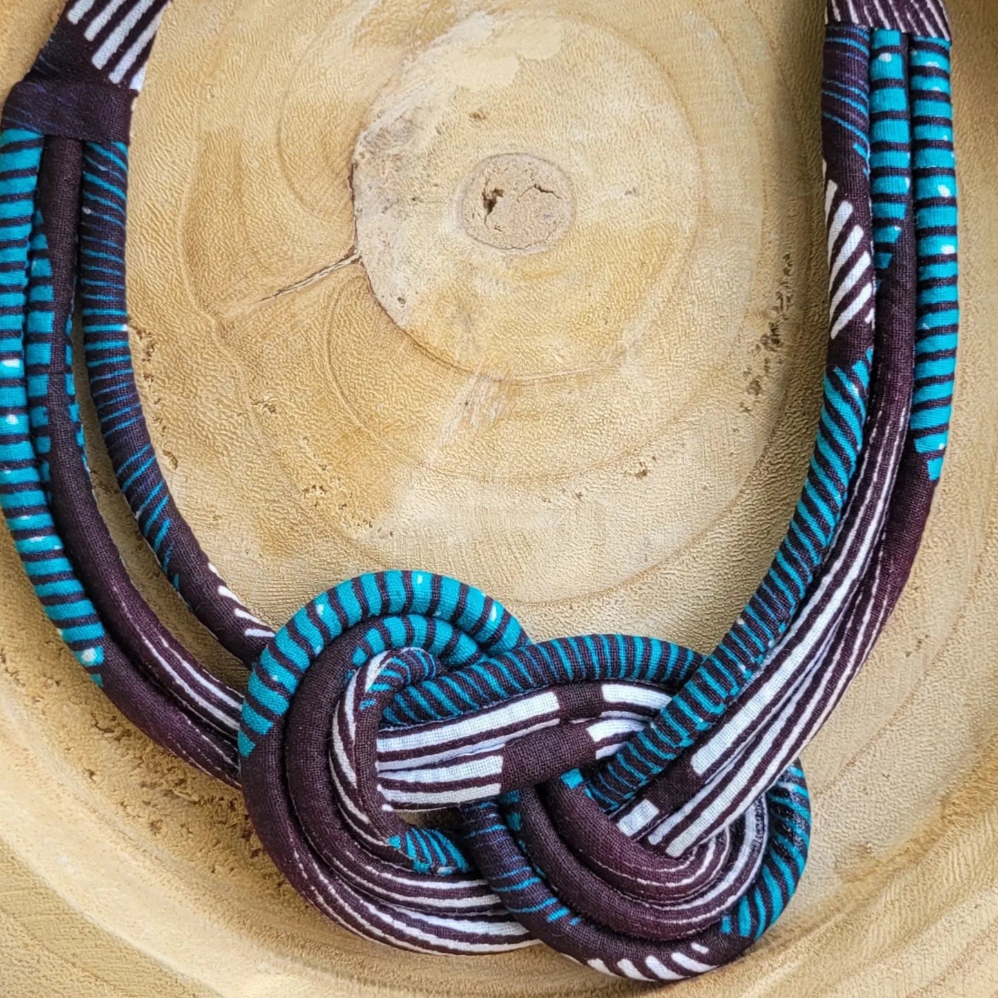 collier en tissu Ndeya, un collier coloré composé de trois rangs de cordons recouverts de tissu wax entrelacés